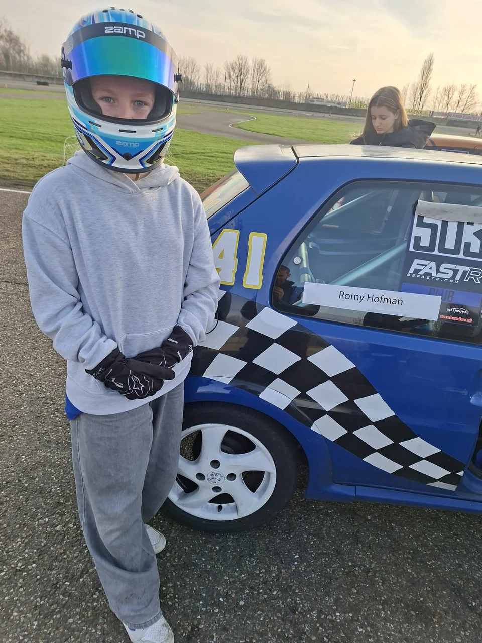 Romy Hofman naast een blauwe race auto